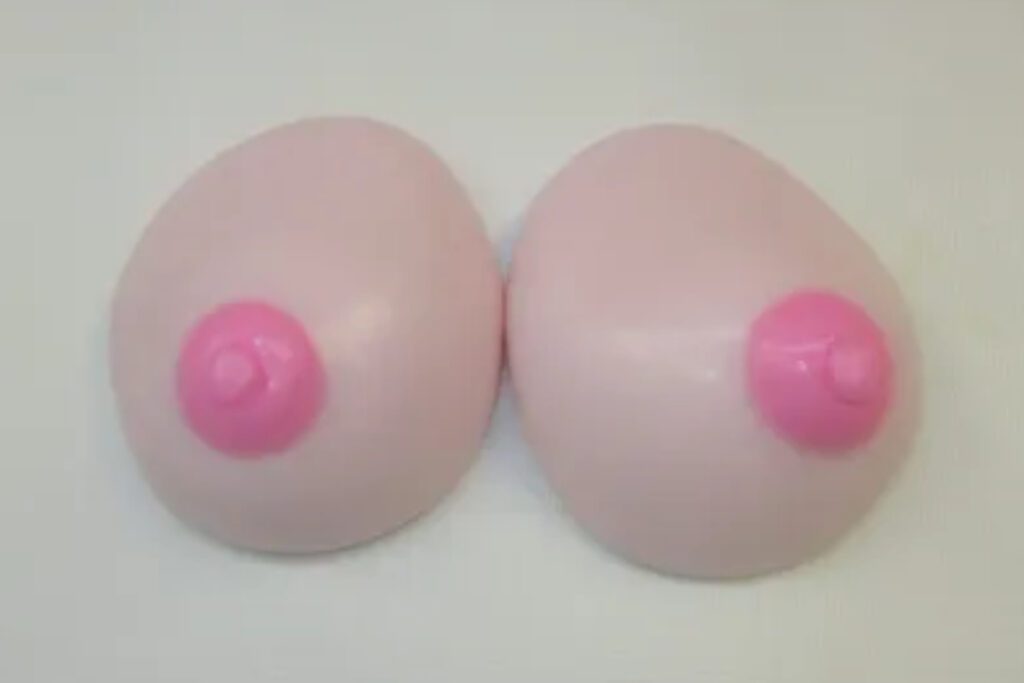 A pair of breasts are shown with pink breast stickers.