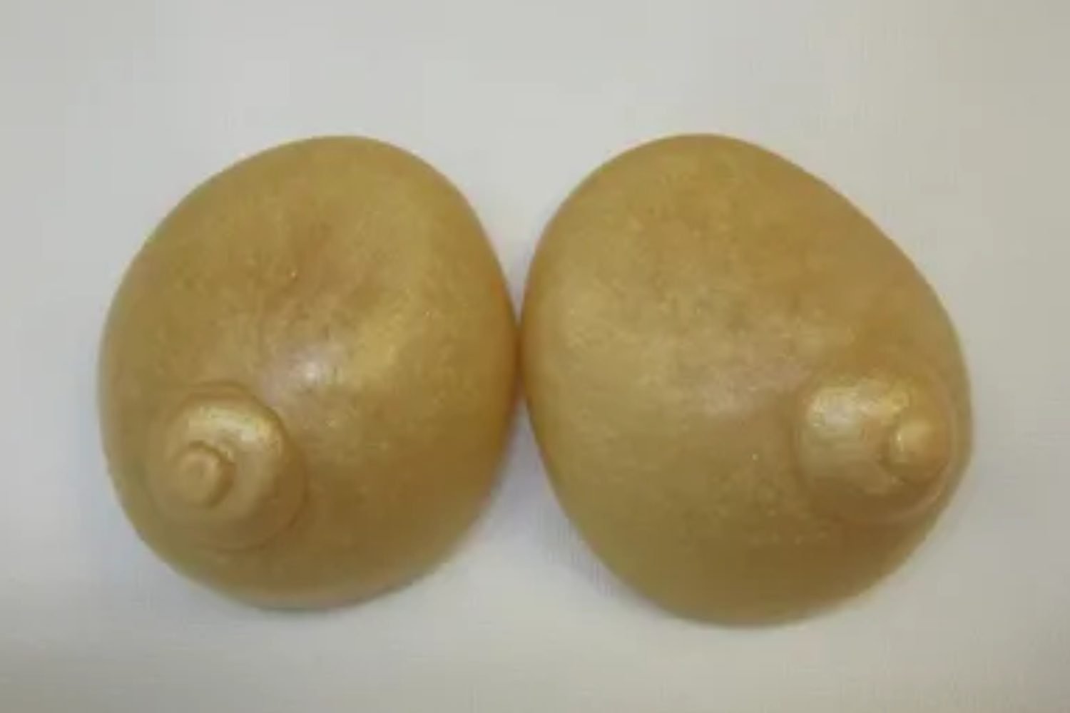 Two large breasts are shown on a white surface.