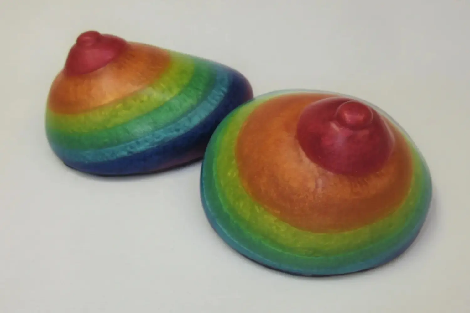 Two rainbow colored bowls sitting on top of a table.