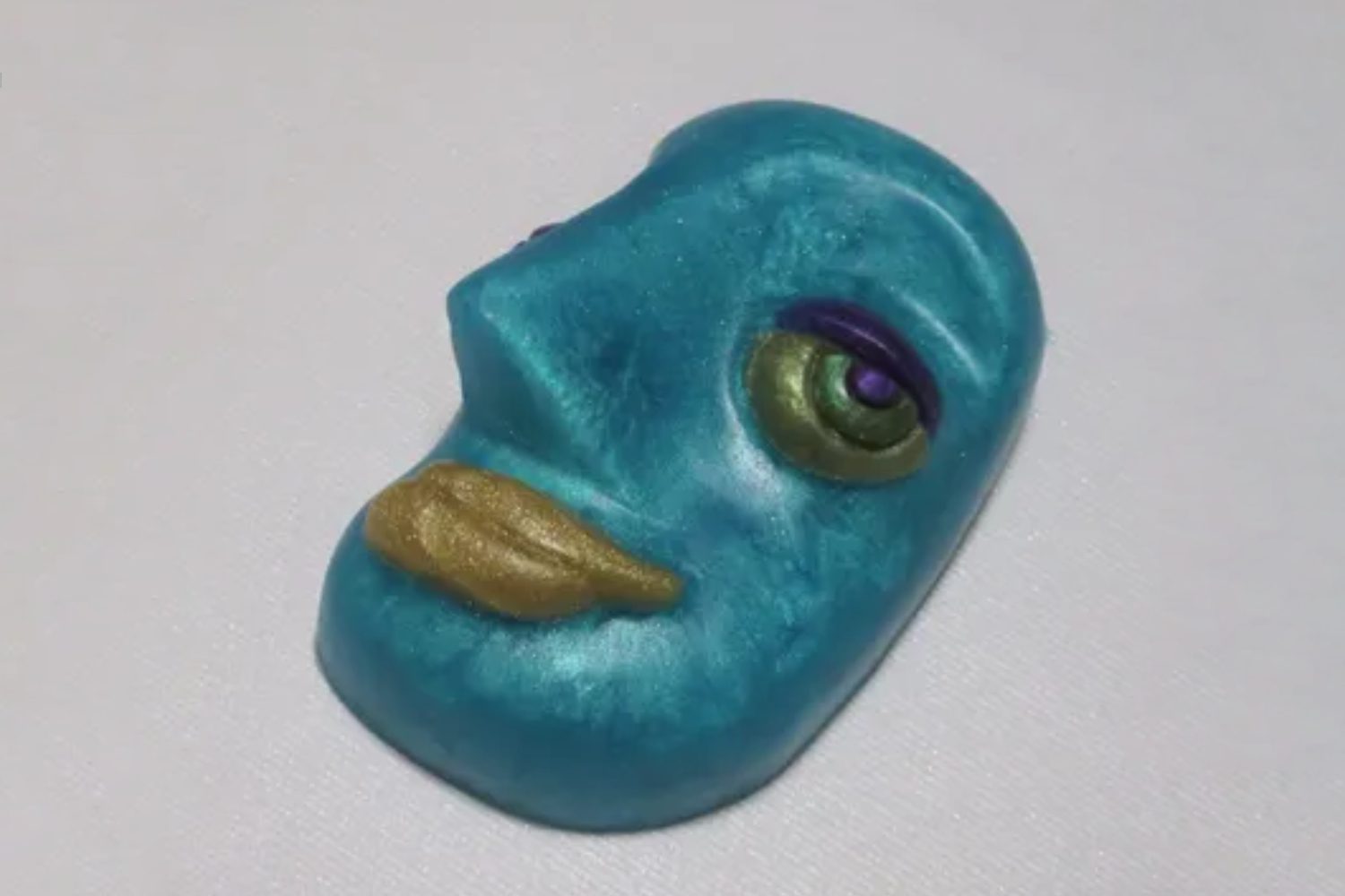 A blue face with a yellow nose and purple eye.