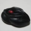 A black object with red eyes and a white background