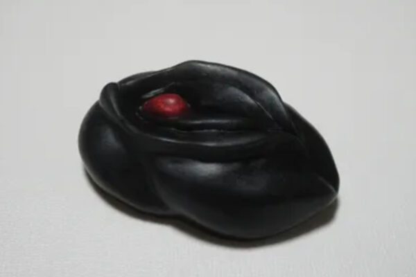 A black object with red eyes and a white background