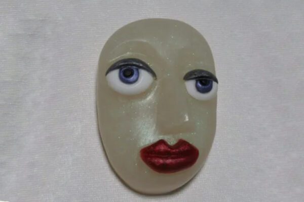A white face with red lips and blue eyes.