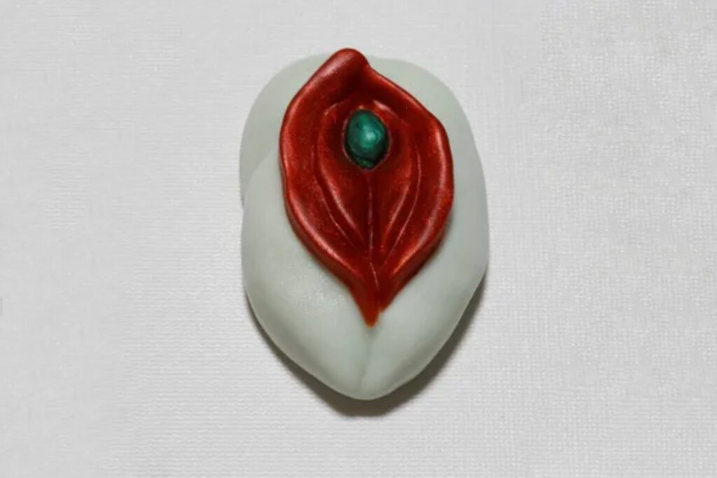 A white and red leaf with a green stone.