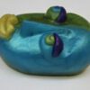 A blue and green clay sculpture of a face.