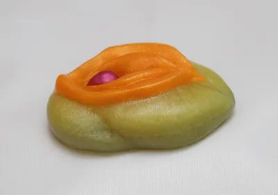 A green and orange object sitting on top of a table.