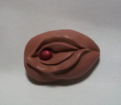 A chocolate piece of art with a red ball in it.