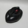 A black mouse with red eyes on top of a white table.