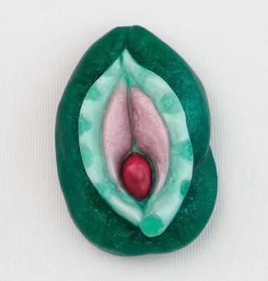 A green and pink piece of art with an open vagina.