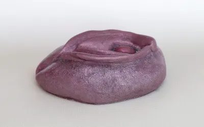 A purple clay bowl sitting on top of a table.