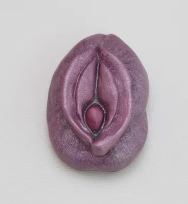 A purple clay sculpture of a woman 's vagina.