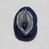 A blue and silver pin with an image of a flower.