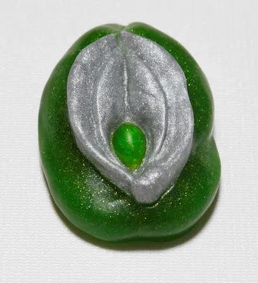 A green and silver bean is sitting on the table.