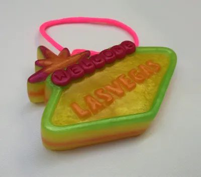 A yellow and green soap with a pink rubber band.
