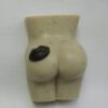 A small white figurine of a buttocks and butt.