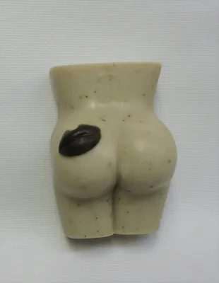 A small white figurine of a buttocks and butt.