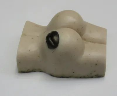 A white toy with two black eyes and a breast.