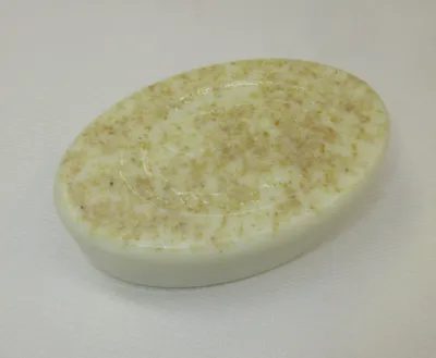 A white oval soap with brown speckles on it.