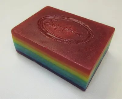 A rainbow colored soap sitting on top of a counter.