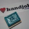 A rubber stamp with scissors on it sitting next to the word " handjob ".