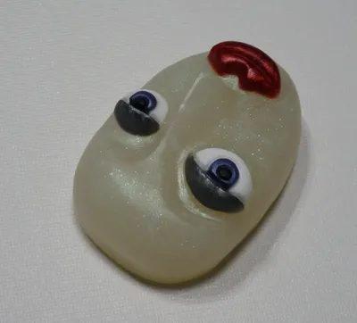 A white face with red eyes and a nose ring.
