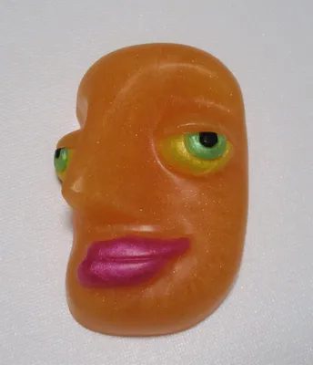 A close up of an orange face with pink eyes