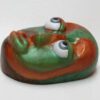 A green and red frog with eyes on it's head.