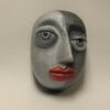 A gray face with red lips on the wall.