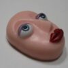 A pink face with red lips and blue eyes.