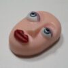 A pink face with blue eyes and red lips.