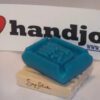 A blue soap bar sitting on top of a wooden block.