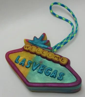 A colorful las vegas sign ornament with the word " welcome " on it.