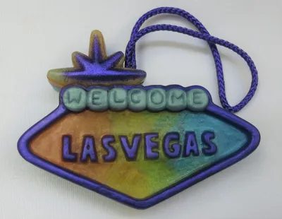 A colorful las vegas sign ornament with the word " welcome " on it.