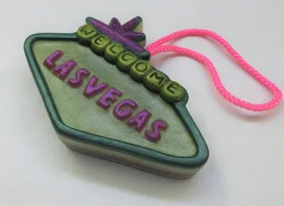 A green and purple sign with the word " las vegas " written on it.