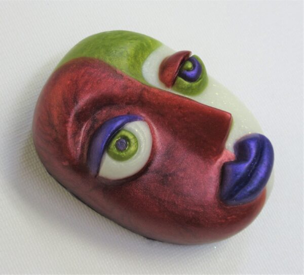 A red face with green eyes and purple nose.