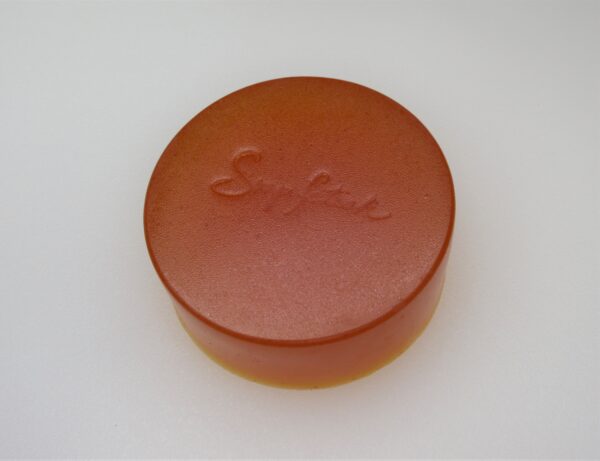 A round orange soap sitting on top of a table.