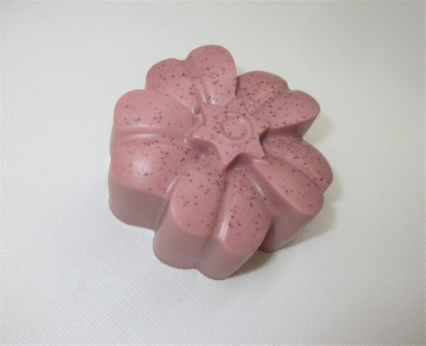 A pink soap sitting on top of a table.