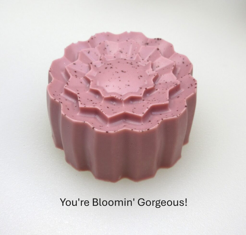 Pink floral soap with specks and text.