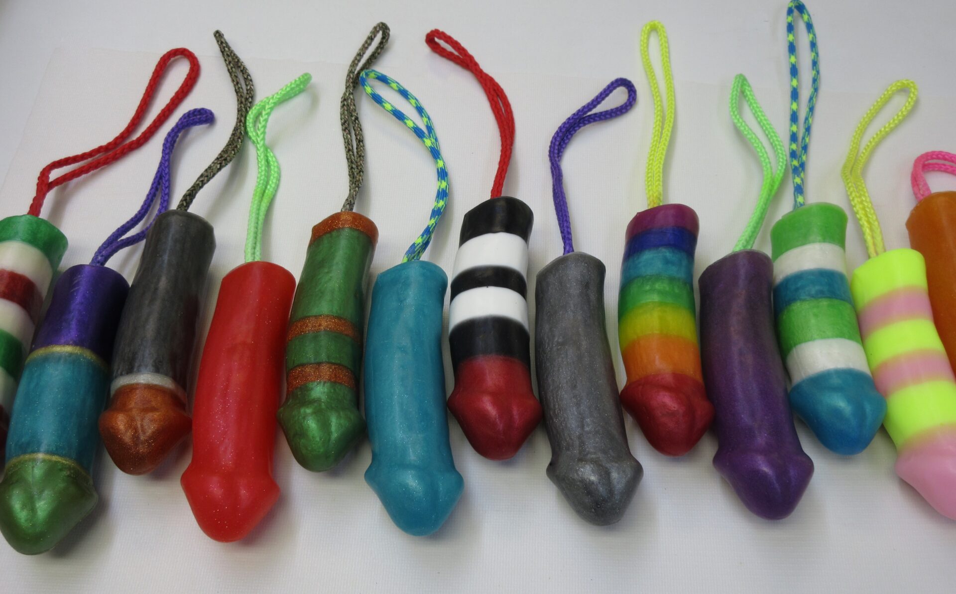 A group of different colored condoms lined up on top of each other.