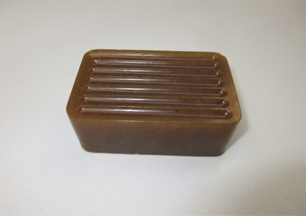 A brown soap bar with wooden sticks on top of it.