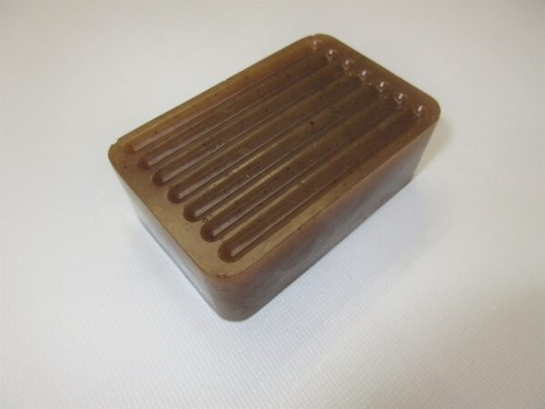 A brown soap dish sitting on top of a counter.