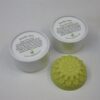 Two white containers with a green soap on top of it.