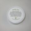 A white container of body butter sitting on top of a table.